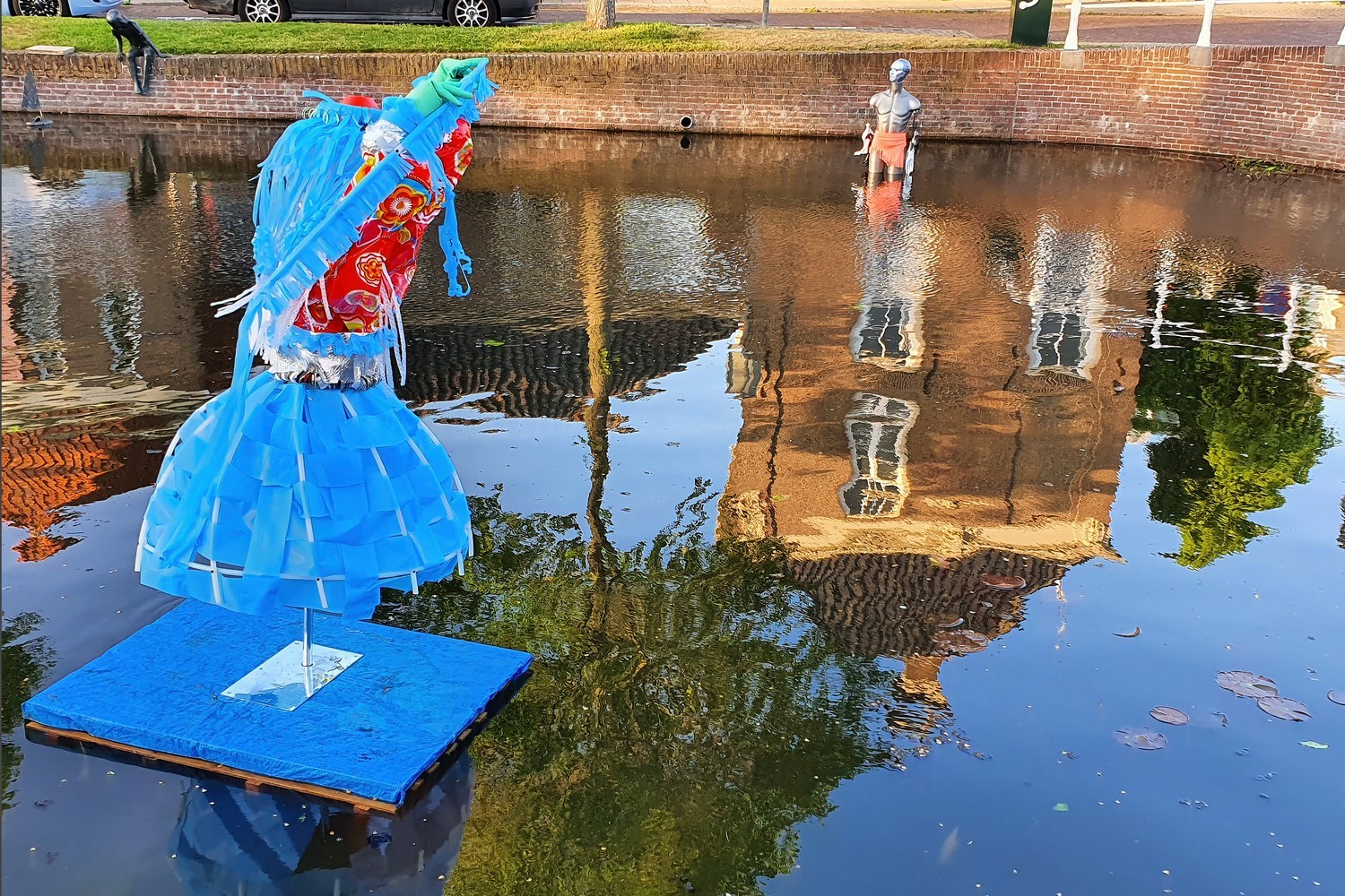 Drijvende sculpturen in de gracht met weerspiegeling